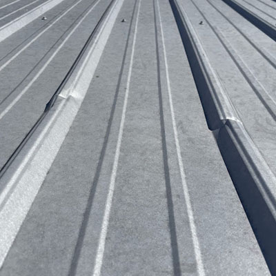 Roof dent away from fasteners and laps